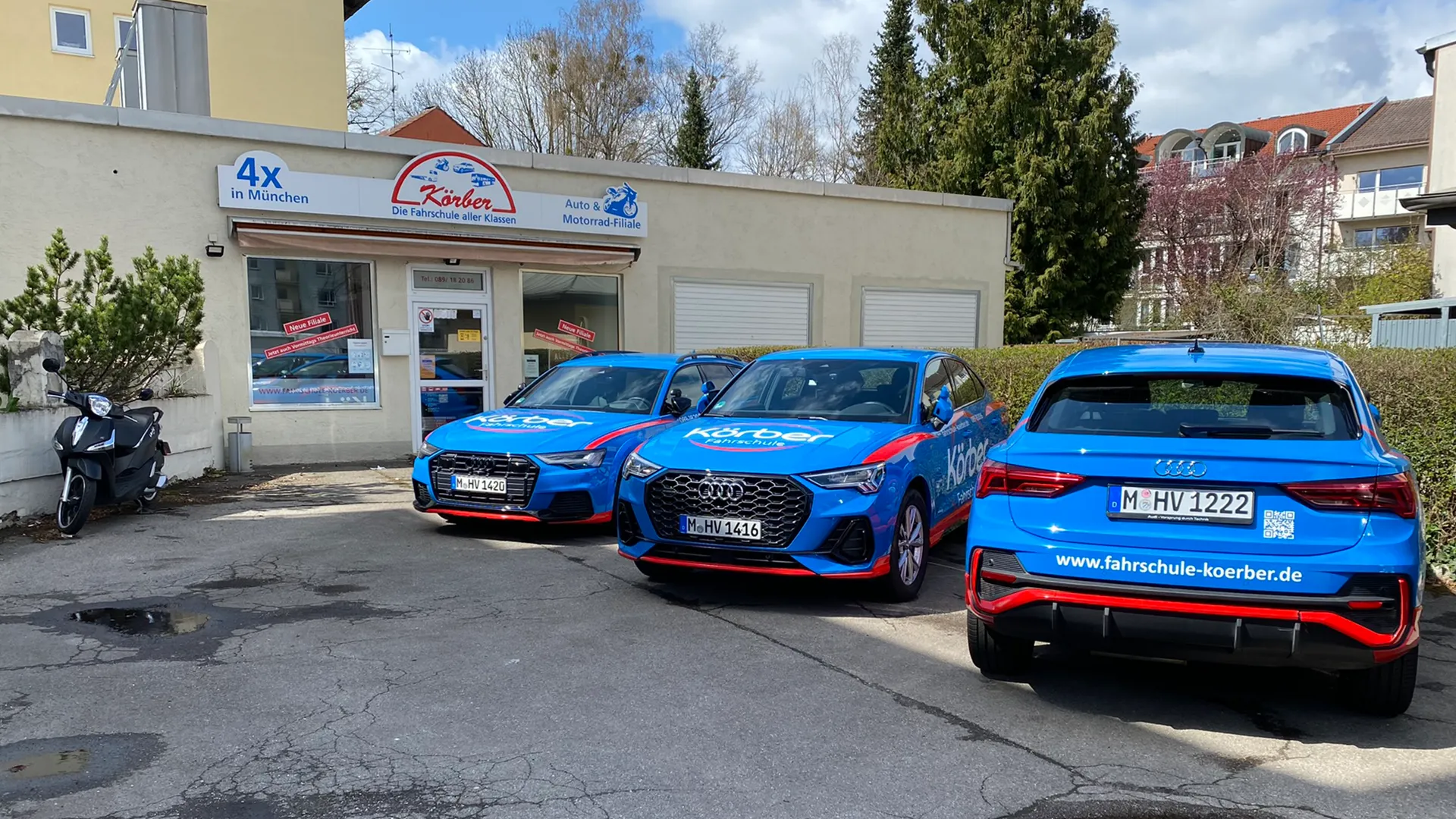 Blaue Körber-Fahrschulautos vor der Fahrschule
